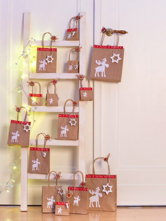 Adventskalender aus Tüten an einer Leiter befestigt